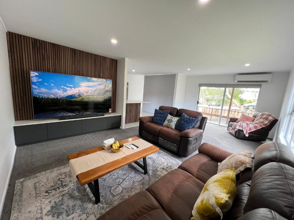 a living room with a large flat screen tv at Private Room in Kawakawa