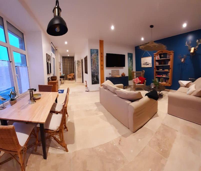 un grand salon avec une table et un canapé dans l'établissement Maison bretonne 400m des plages Vélos gratuits, à Plouguerneau