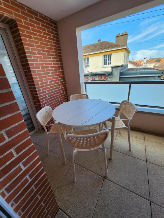 un patio con tavolo e sedie sul balcone. di Appartement Plein Centre a Saint-Brévin-les-Pins