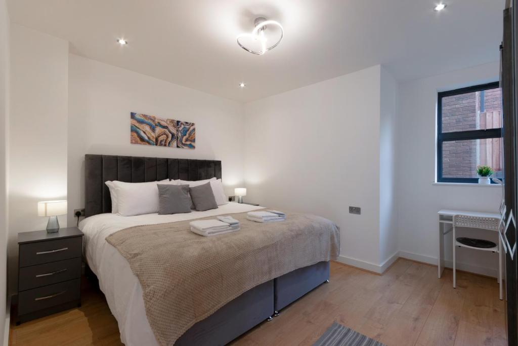 um quarto com uma cama grande e paredes brancas em Modern Two Bedrooms Flat in Julien Road, CR5, London em Coulsdon