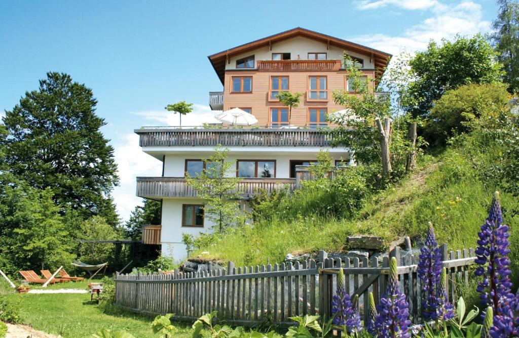 una casa en la cima de una colina con una valla en Panoramahotel Wagner - Das Biohotel am Semmering, en Semmering