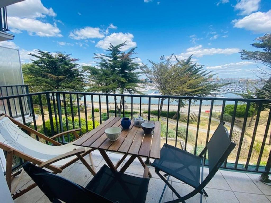une table et des chaises en bois sur un balcon dans l'établissement L'Ancre, à Saint-Gilles-Croix-de-Vie