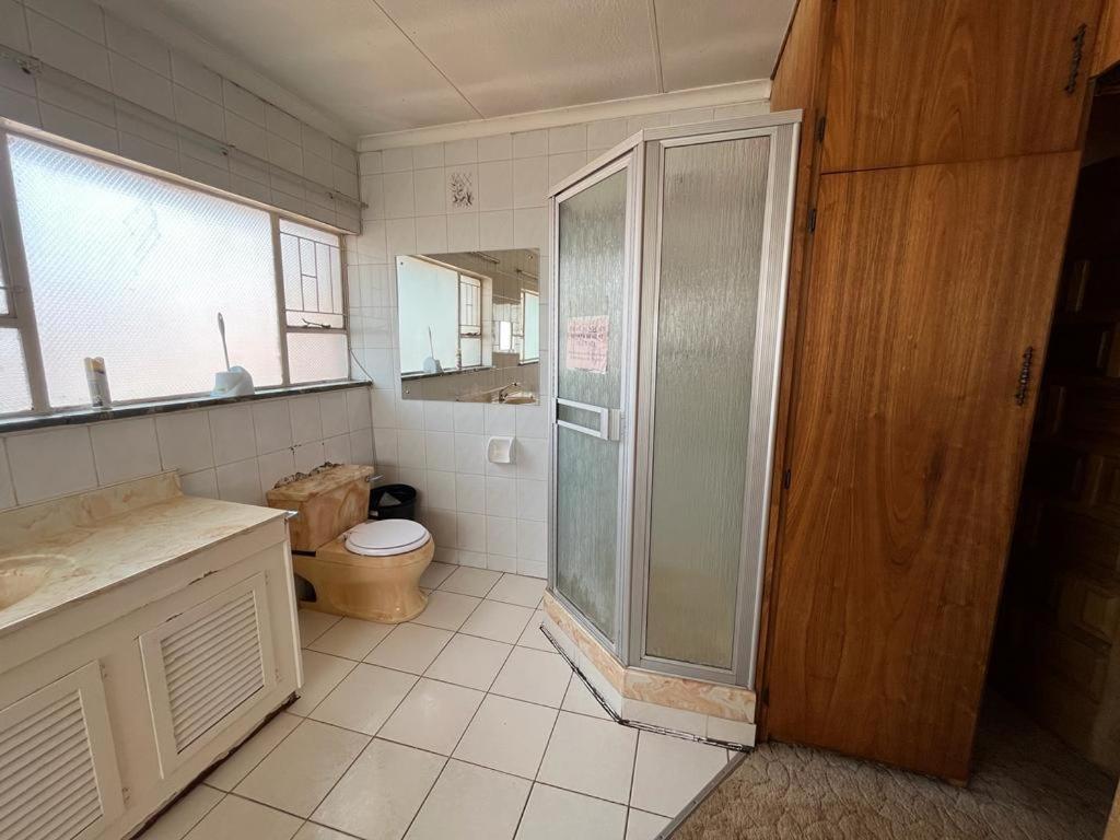 a bathroom with a shower and a toilet at Kharimbi Camp House in Brakpan