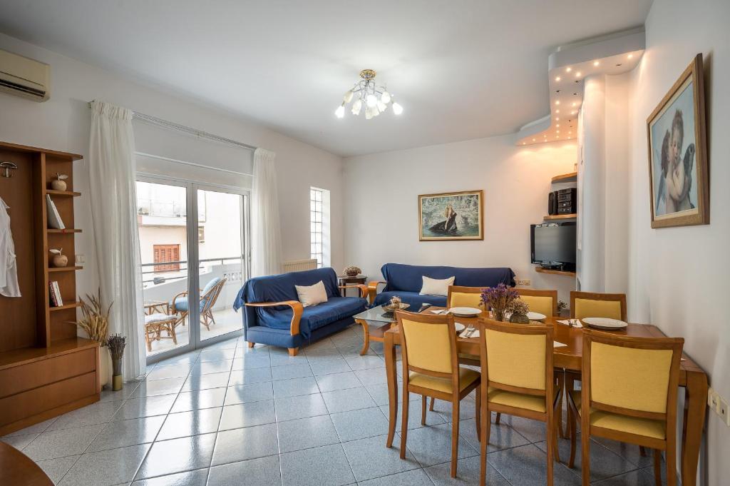 sala de estar con mesa y sofá azul en apartment, en Néa Alikarnassós