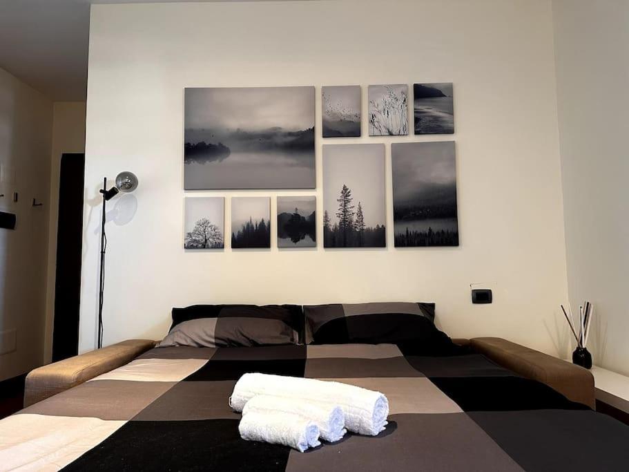 a bedroom with a bed with four pictures on the wall at Ampia Piscina Condominiale [Nuovo Monolocale] in Mostacciano