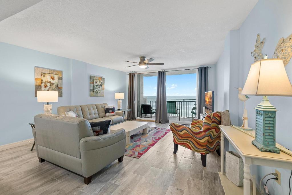 a living room with a couch and a chair at Coronado Towers 703 in New Smyrna Beach