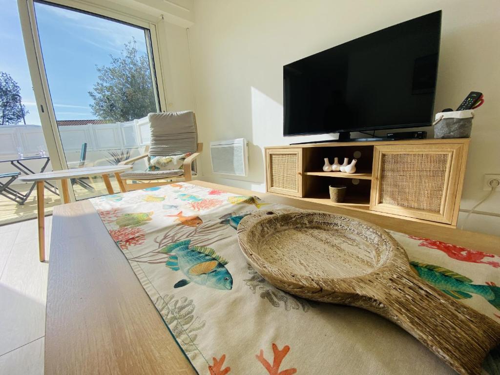 un soggiorno con TV a schermo piatto e tappeto di Maison renovee avec gout 700m de la plage a Saint-Gilles-Croix-de-Vie