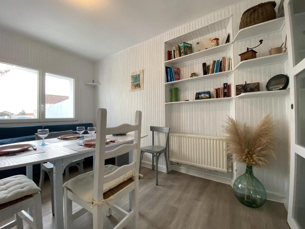 une salle à manger avec une table et une table et des chaises dans l'établissement La Petite Hilairoise, à Saint-Hilaire-de-Riez