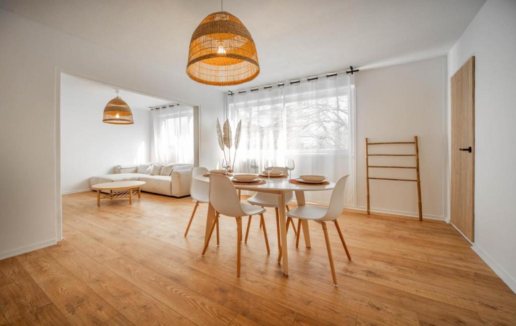 un salon blanc avec une table et des chaises dans l'établissement Le Balinais - Appartement à Chalon-sur-Saône, à Chalon-sur-Saône