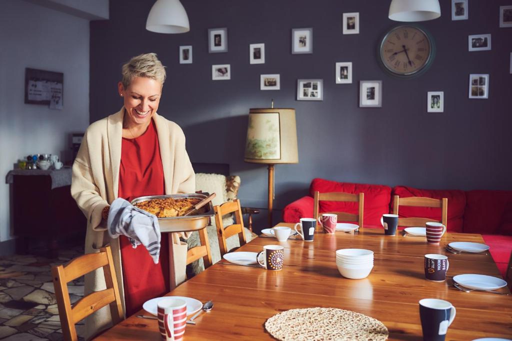 a woman sitting at a table with a plate of food at Kraina Szeptów in Stronie Śląskie