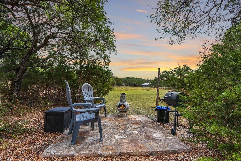 een grill en twee stoelen zittend op een rots met een barbecue bij Cabins at Flite Acres- Coyote Cabin in Wimberley