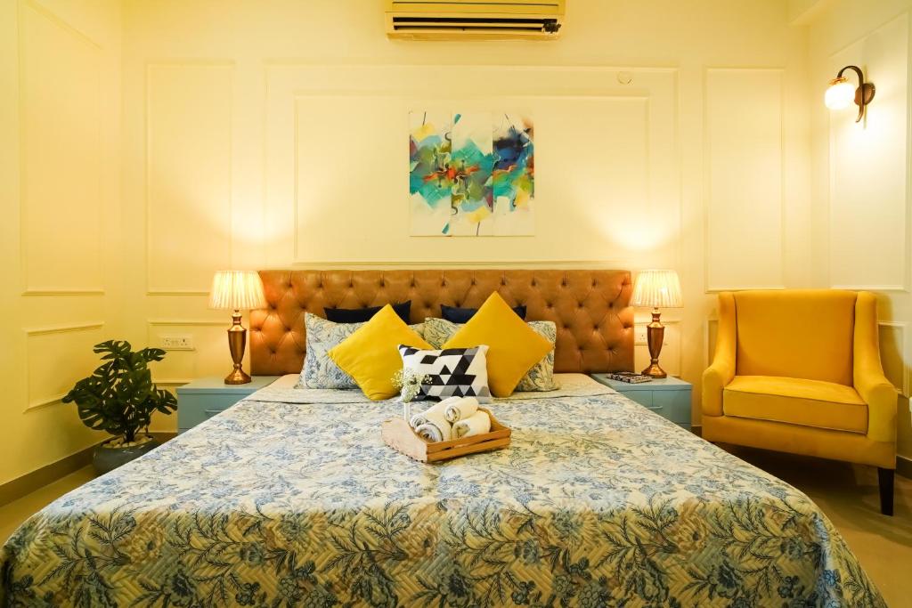 a bedroom with a bed and a yellow chair at Cozy Inn in Gurgaon