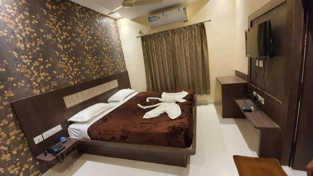 a hotel room with a bed with a towel on it at Hotel Home Town Puri - Lift - Parking - Near Golden Beach - Excellent Service Recommended in Puri