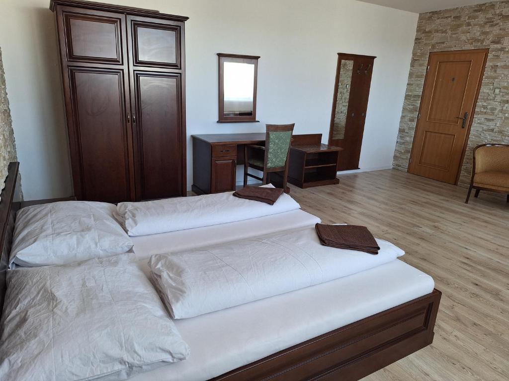 two beds in a room with a desk and a desk at Laguna ubytovanie 2 B in Nemšová