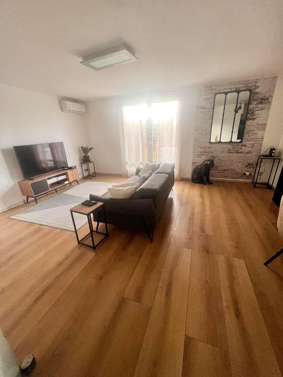 uma sala de estar com um sofá e um cão em Duplex Ophélie em Saint-Denis