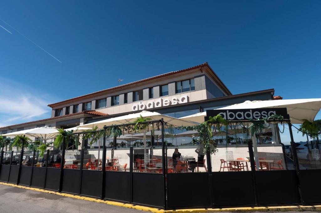 a restaurant with tables and chairs in front of a building at Restaurante Hotel Abadesa in Villagonzalo-Pedernales