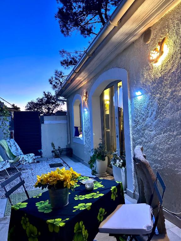 - une table avec un vase de fleurs sur la terrasse dans l'établissement les pivoines, à Borgo