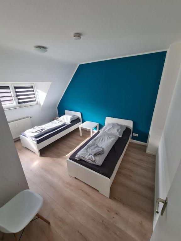 2 Betten in einem Zimmer mit blauer Wand in der Unterkunft Schöne 3 Zimmer Apartment Netflix+Prime in Krefeld