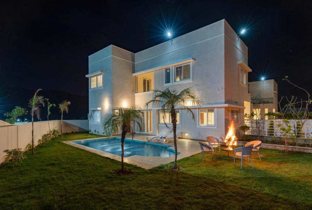 a house with a swimming pool at night at ELIVAAS Shourya Eden Luxe 3BHK Villa with Pvt Pool, Udaipur in Udaipur