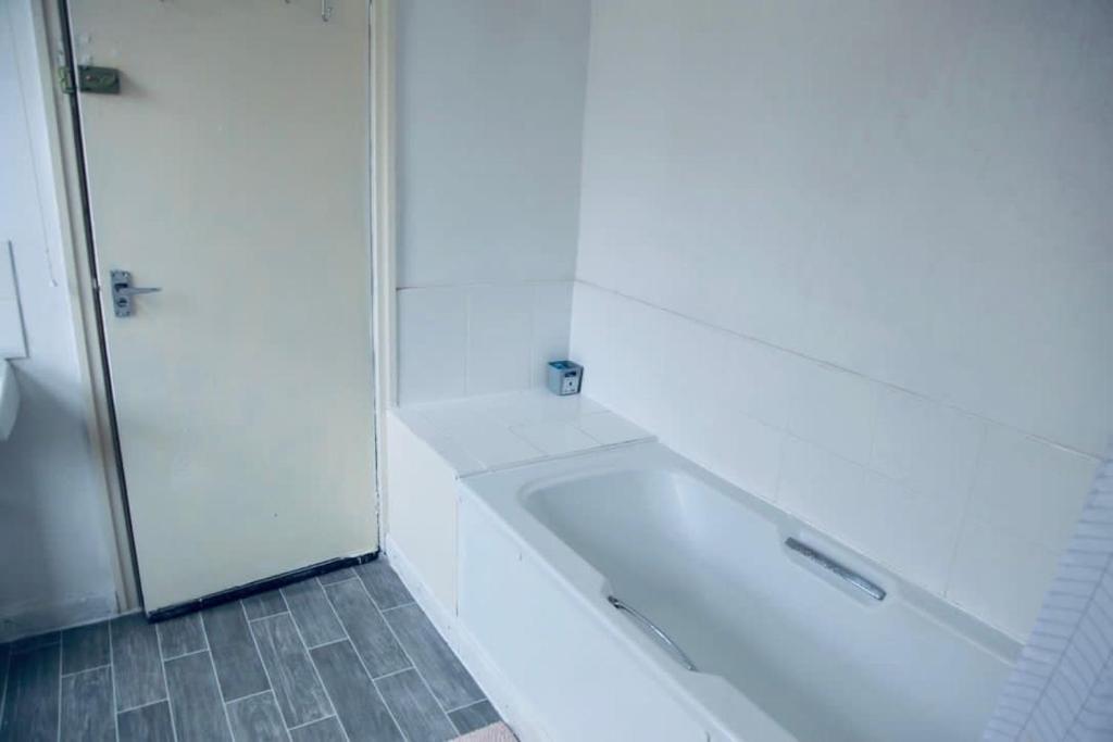 een witte badkamer met een bad en een douche bij PEACEFULLY AND CENTRALLY LOCATED DOUBLE BEDROOM in Hunslet