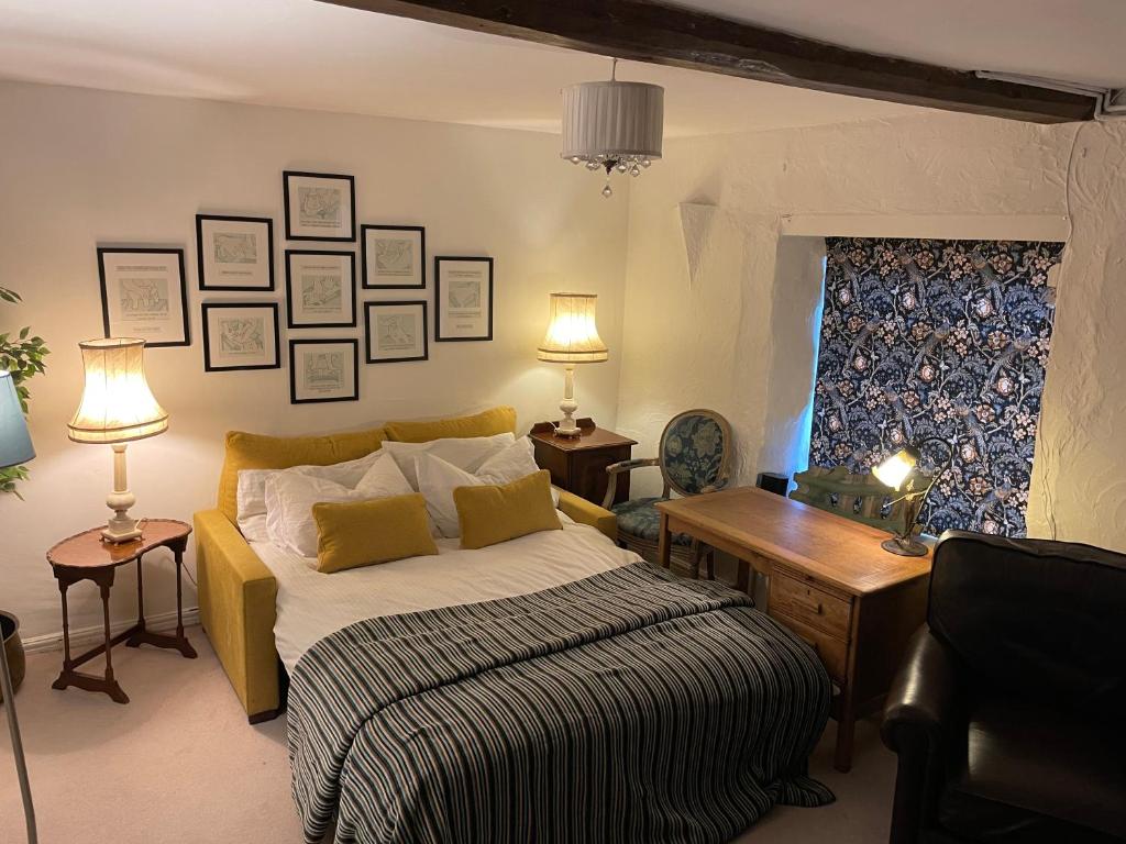 a bedroom with a bed and a desk and two lamps at The Therapy Rooms Holmfirth Holiday Let in Holmfirth