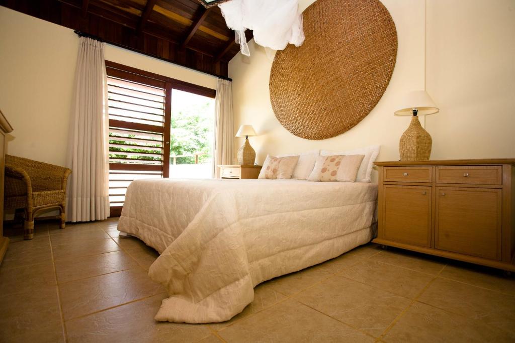 ein Schlafzimmer mit einem Bett und einem großen Fenster in der Unterkunft Pipa Hills Casa Tulipa in Pipa