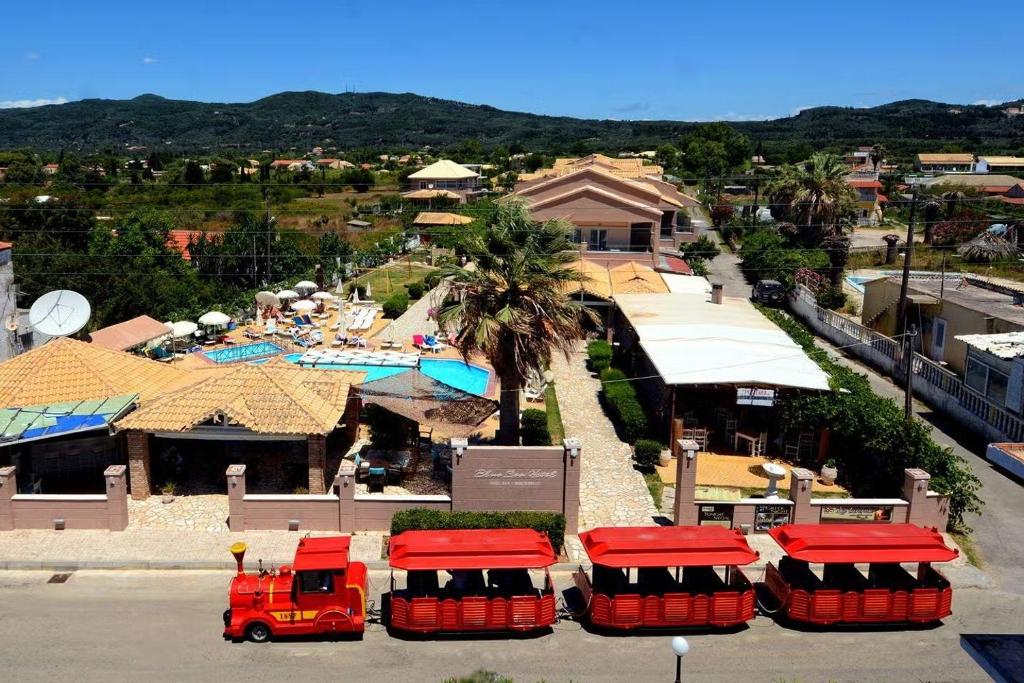 un gruppo di camion rossi parcheggiati di fronte a un resort di The Blue Sea Hotel ad Agios Georgios