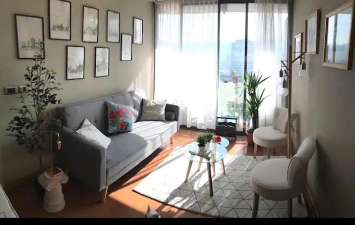 Luminosa habitacion con baño privado en el centro de Providencia في سانتياغو: غرفة معيشة مع أريكة وطاولة