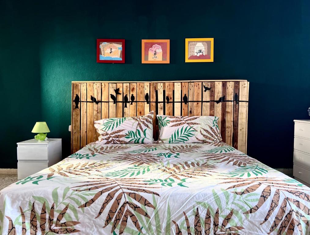 um quarto com uma cama e uma cabeceira em madeira em The Green House on the sea em Pozzallo