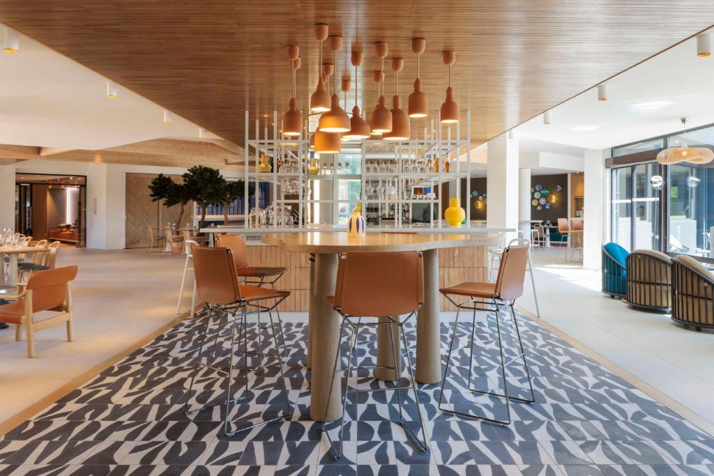 a dining room with a table and chairs at Hilton Garden Inn Marseille Provence Airport in Marignane