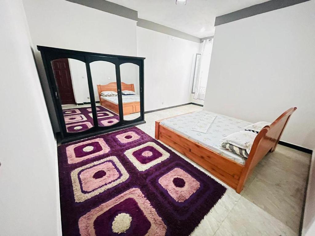 ein kleines Schlafzimmer mit einem Bett und einem Teppich in der Unterkunft Eddy's in Mutumba