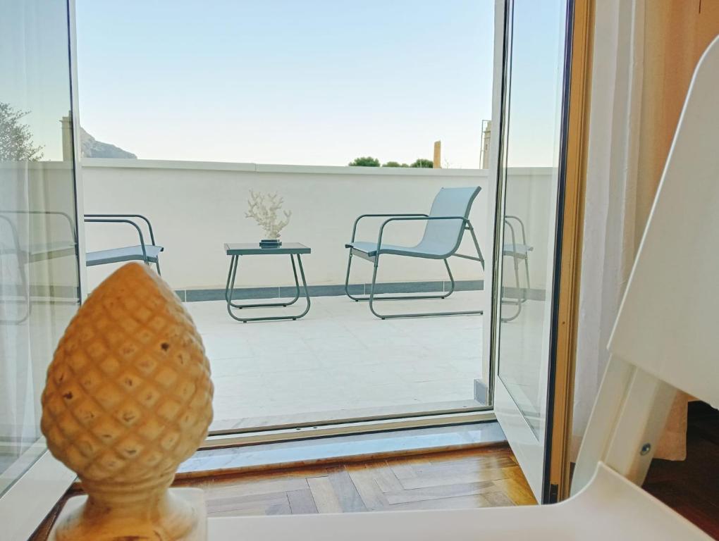 Habitación con vistas a un balcón con sillas y mesa. en Le Terrazze di Mineo, en Cinisi
