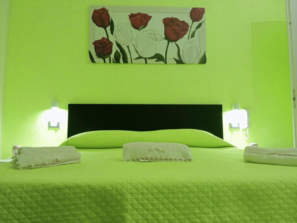 a green bedroom with a large green bed with two pillows at Casa vacanze valentino in Avola