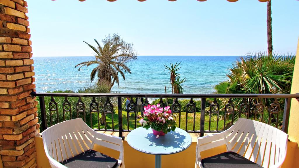 balkon ze stołem i krzesłami oraz oceanem w obiekcie Sea Sand Sun, Glyfada Corfu no17 w mieście Glifada