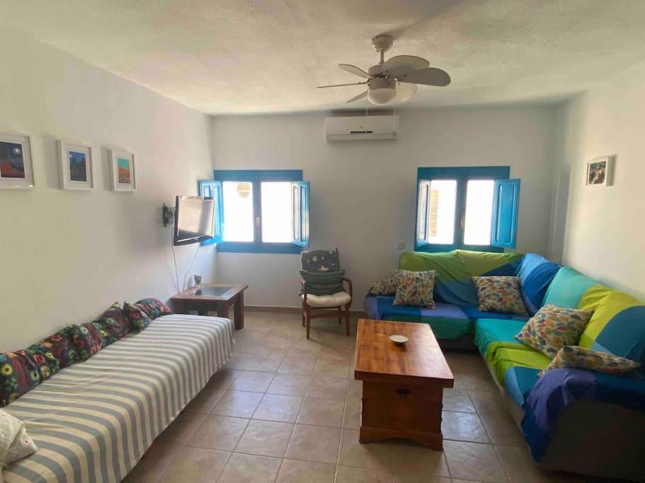 een woonkamer met 2 banken en een tafel bij Apartamento Mare Nostrum Centro Aguamarga in Agua Amarga