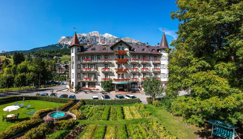 un grand bâtiment avec un jardin en face dans l'établissement Franceschi Park Hotel, à Cortina dʼAmpezzo