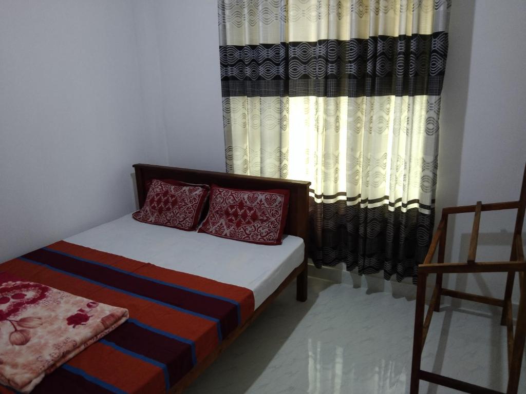 een slaapkamer met een bed en een raam met gordijnen bij Green Haven Guest Inn in Badulla