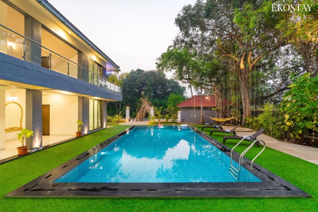 a swimming pool in the backyard of a house at EKOSTAY Luxe - Casa De Atlantis in Alibaug