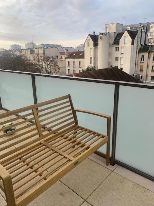 eine Holzbank auf dem Balkon in der Unterkunft Grand Appartement Proche Paris Idéal Paris 2024 in Ivry-sur-Seine
