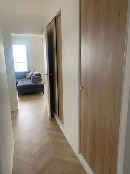 einen Flur mit Tür und Couch in einem Zimmer in der Unterkunft Grand Appartement Proche Paris Idéal Paris 2024 in Ivry-sur-Seine