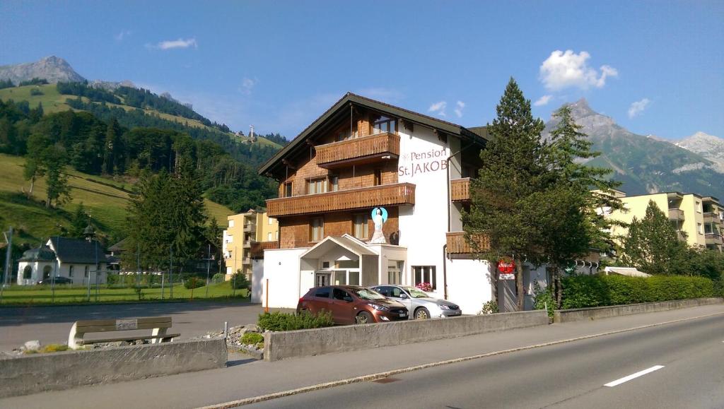 un bâtiment situé sur le côté d'une route à côté d'une rue dans l'établissement Pension St. Jakob, à Engelberg