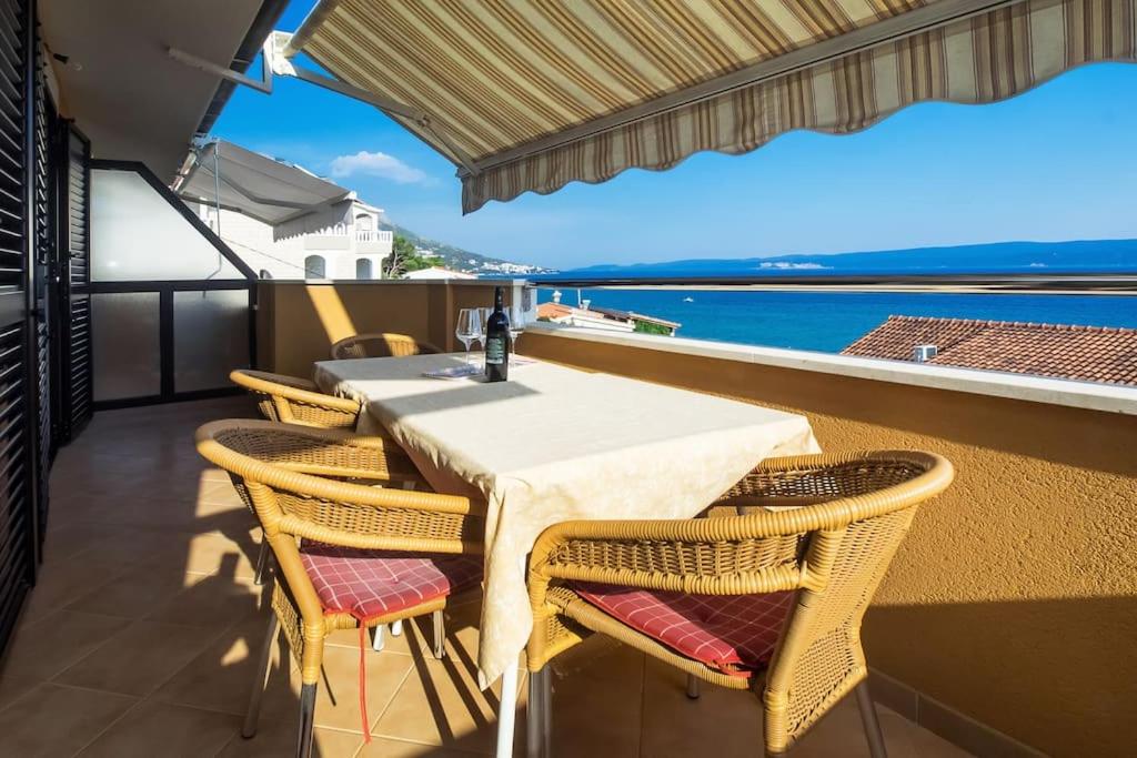 un tavolo e sedie su un balcone con vista sull'oceano di Apartman Bruna a Duće