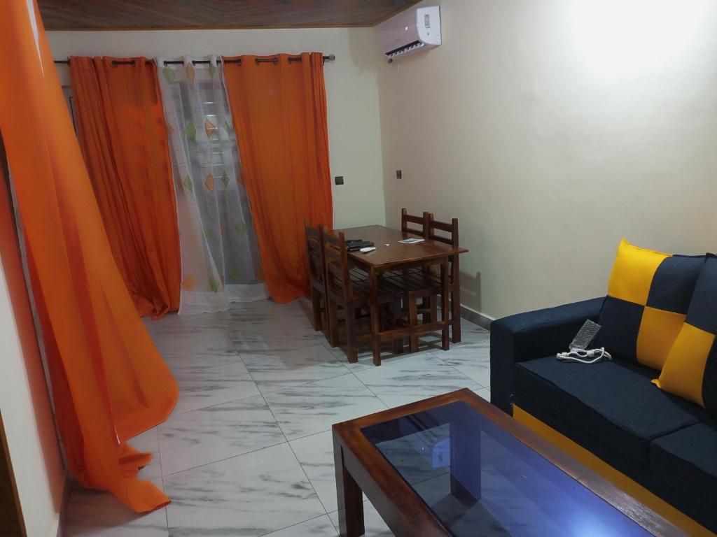 sala de estar con sofá y mesa en RÉSIDENCE MEUBLÉE CYMAT en Douala