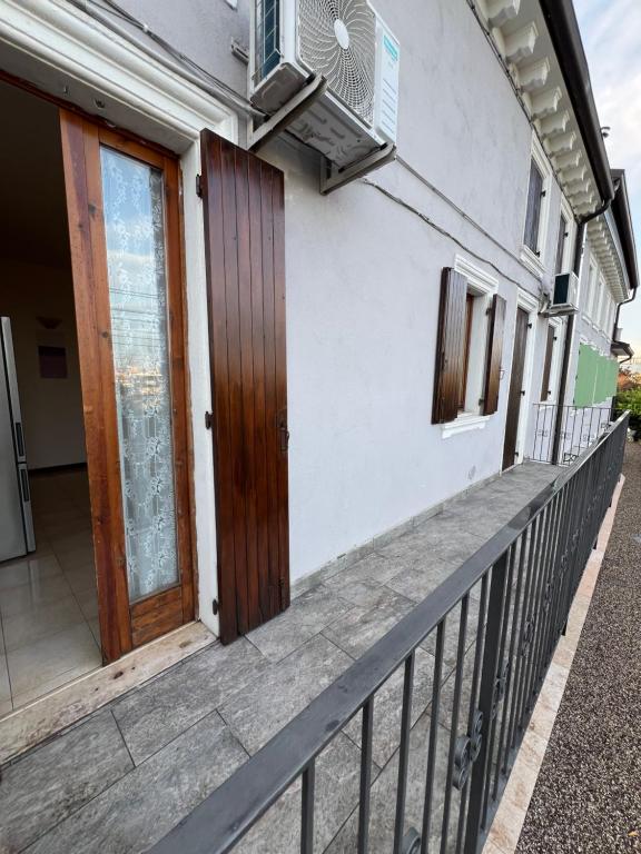 - Balcón de casa con puerta y ventilador en Rooms Pineta, en Verona