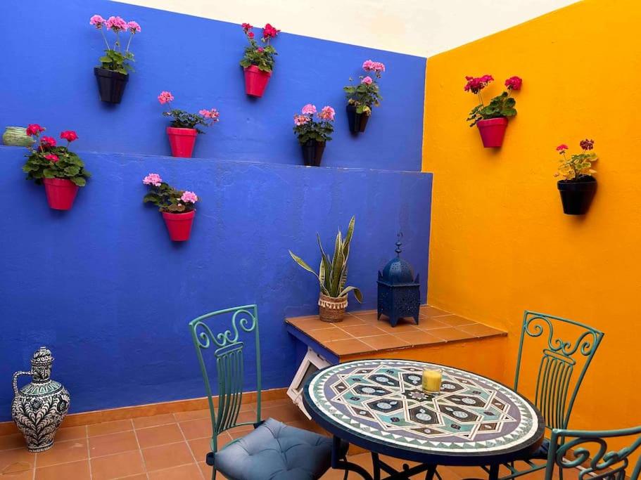 a colorful room with a table and chairs and potted plants at Picasso - Spacious Apartment in Old Town Nerja in Nerja