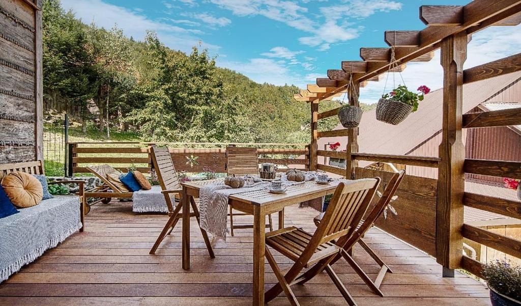 un patio con mesa y sillas en una terraza en Lux Constance Cottage, en Tylmanowa