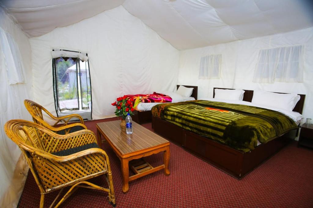 1 dormitorio con 1 cama, mesa y sillas en Nubra Escapes, en Hundar