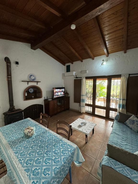 uma sala de estar com uma mesa e um sofá em L'Uliveto HOLIDAY HOUSE -Casa Vacanze Indipendente- em Muravera