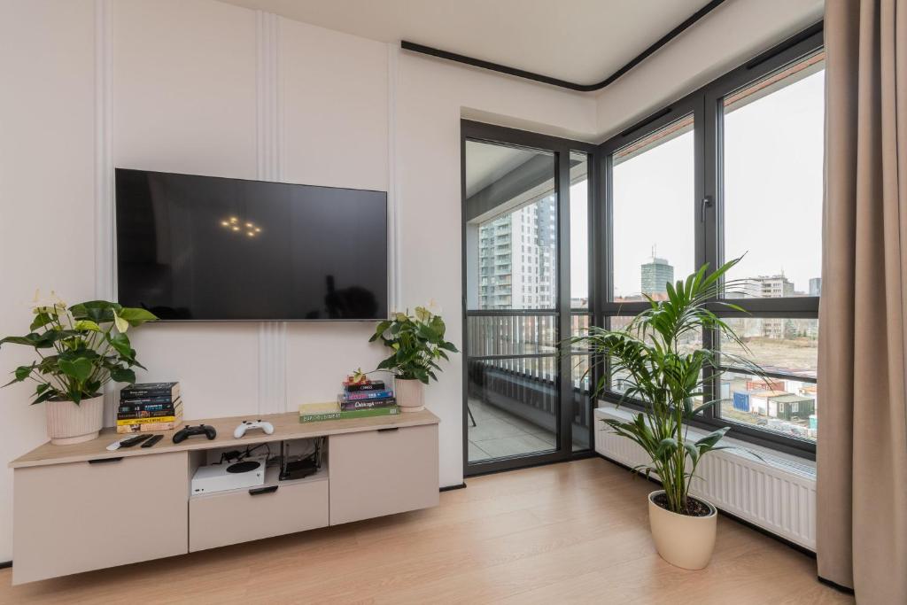 ein Wohnzimmer mit einem TV und einem großen Fenster in der Unterkunft Doki - Luxury Voyager by Grand Apartments in Danzig
