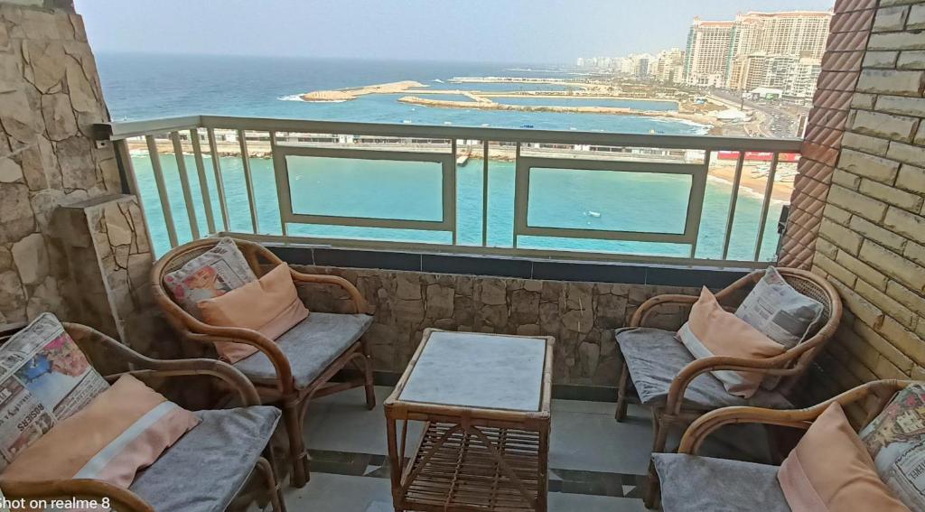 balcone con sedie, tavolo e vista sull'oceano di Charming Seaview Condo in Gleem ad Alessandria d'Egitto